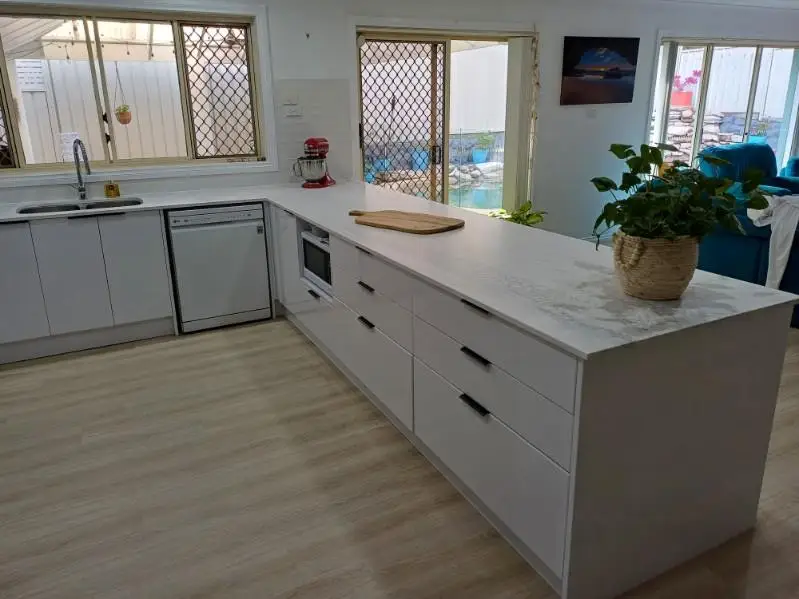 Kitchen peninsula with deep pan drawers, an integrated microwave and a dishwasher beside the sink run